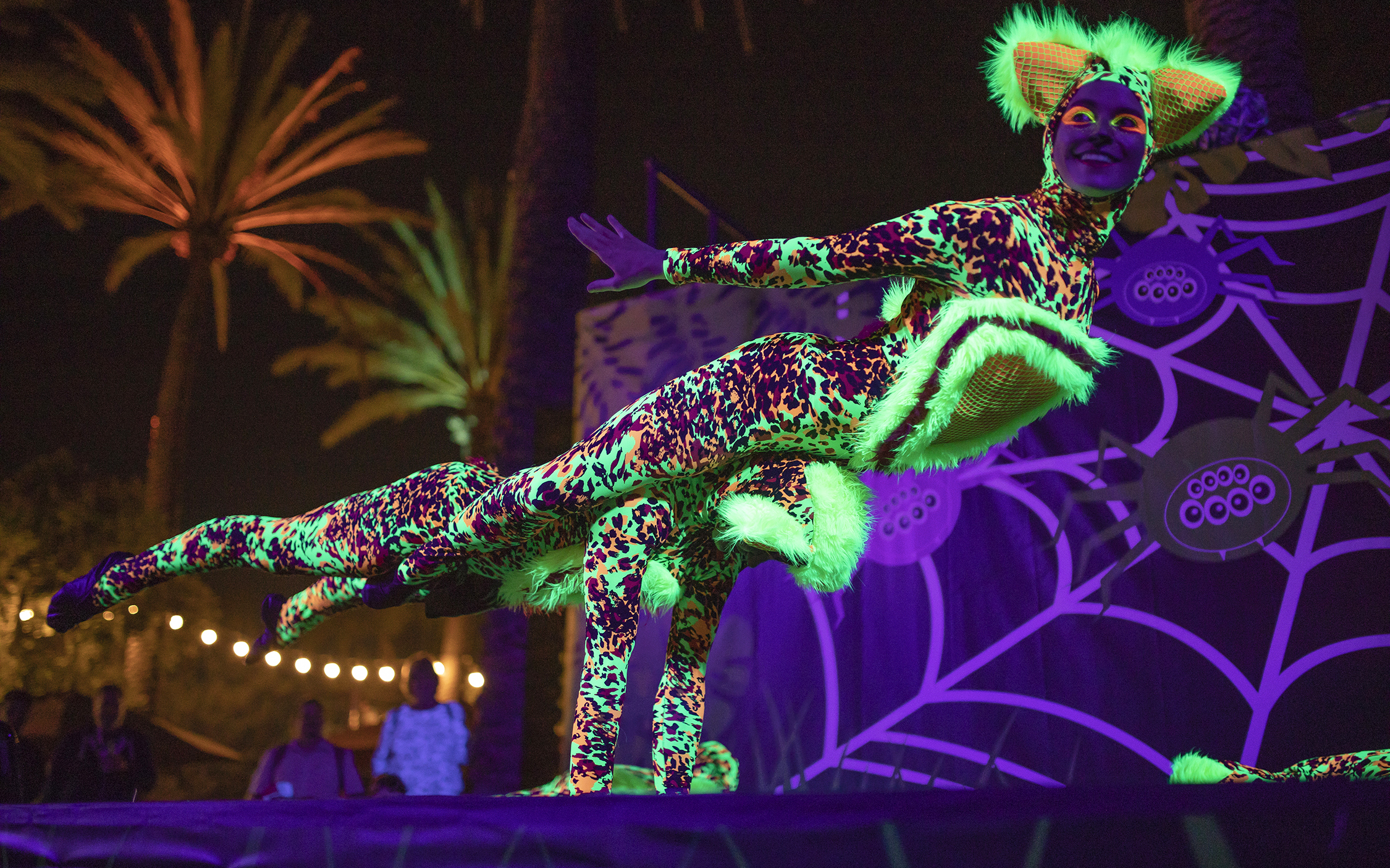 Performer in glowing costume at San Diego Zoo nighttime event.