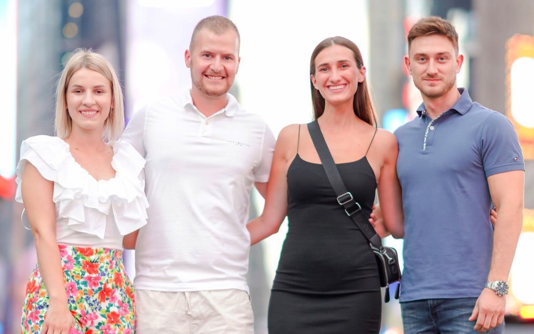 Group posing for a photoshoot in Times Square, NYC.