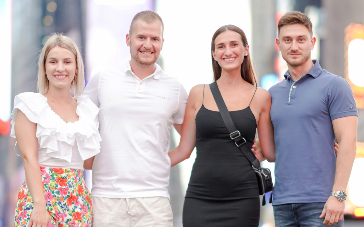 Group posing for a photoshoot in Times Square, NYC.