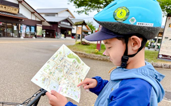 Child with helmet holding a map during Asuka Nara Historical E-bike tour, Nara.