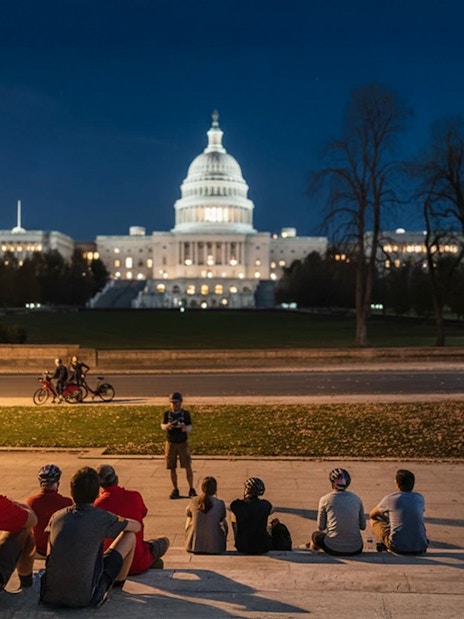 Tourists on a night biking tour listening to a guide in front of the Capitol Building, Washington D.C.