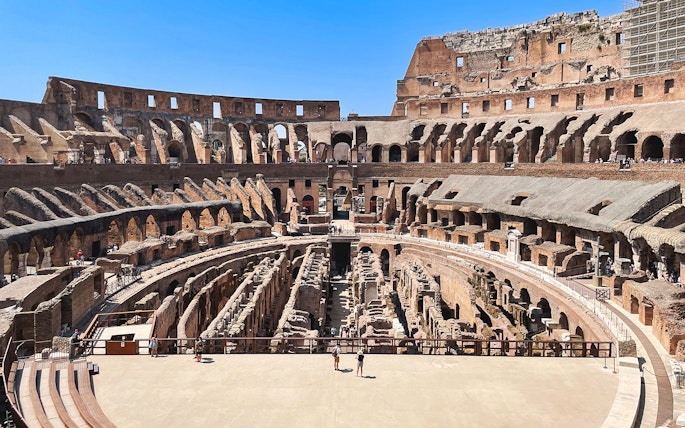 Tourists exploring the Colosseum arena in Rome, Italy.