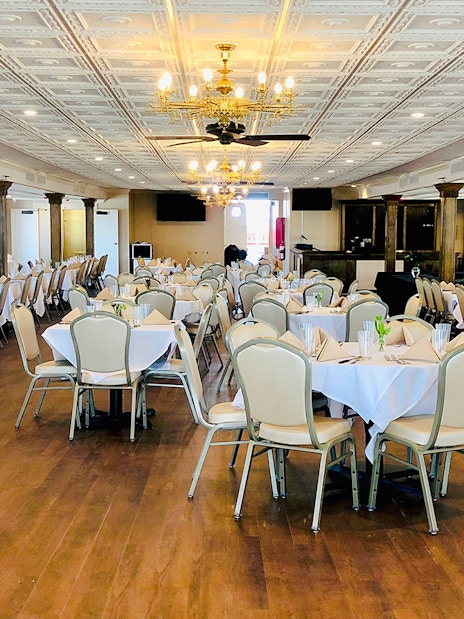 Interior dining area of CITY of NEW ORLEANS Riverboat with set tables and chandeliers.
