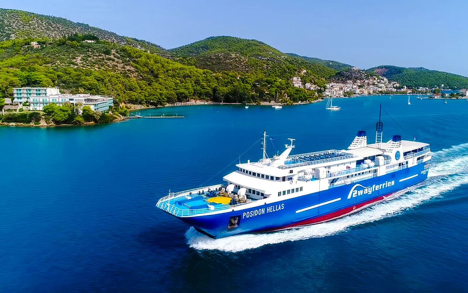 Ferry sailing near Aegina, Greece with lush hills and coastal buildings in the background.