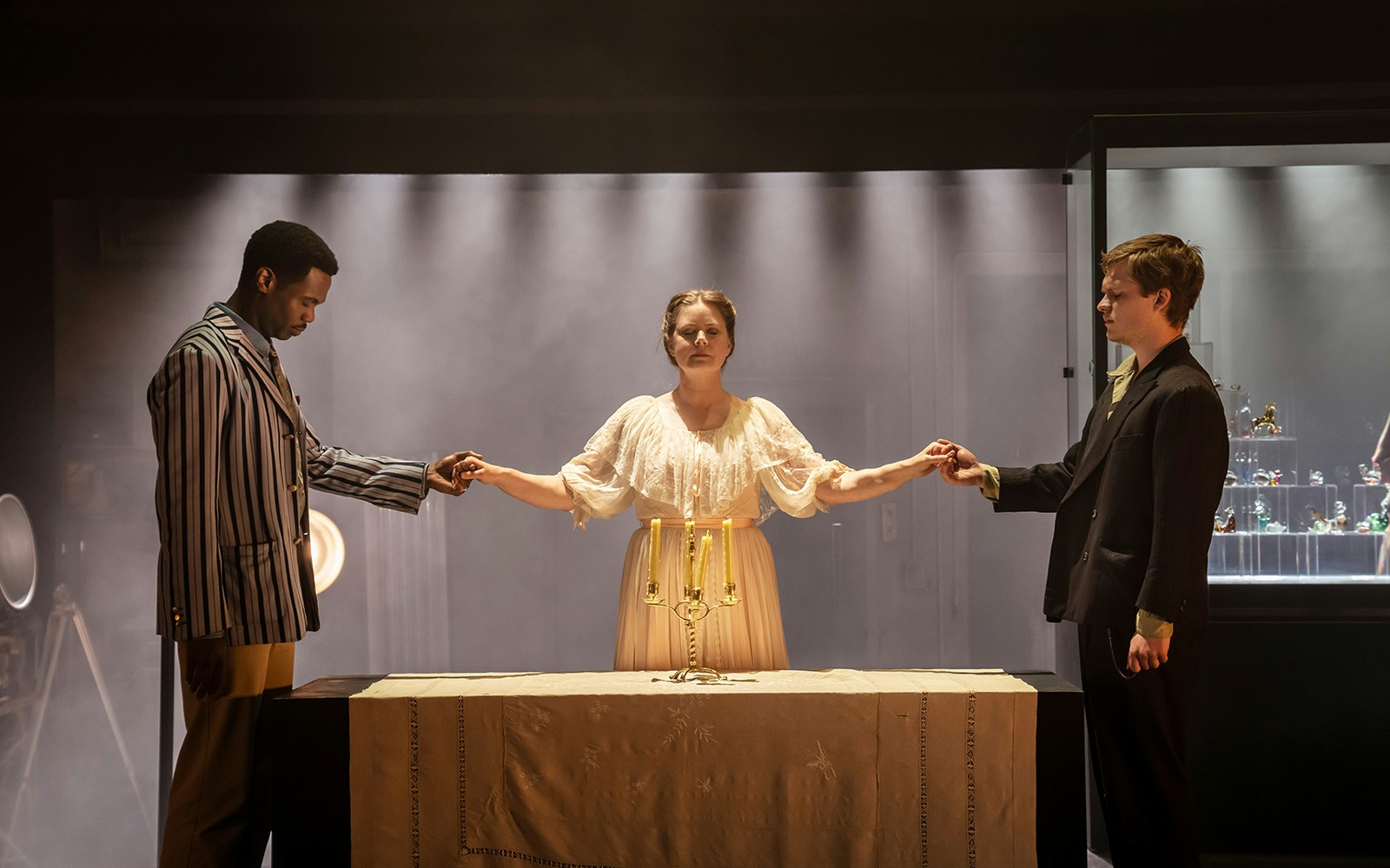 Actors performing a scene from "The Glass Menagerie" with a table and glass figurines.