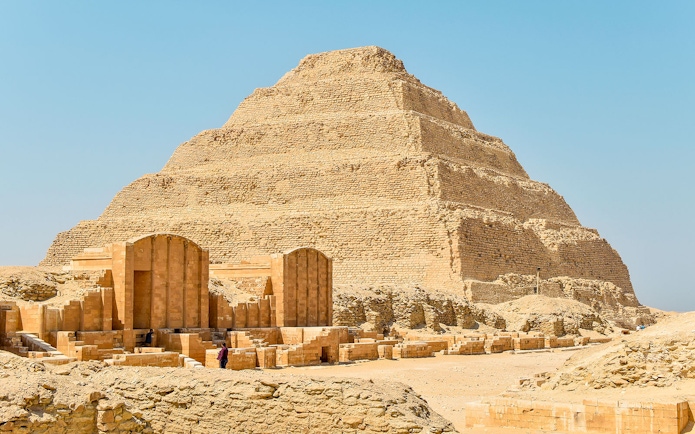 Step Pyramid of Djoser at Saqqara, Egypt under a clear sky.