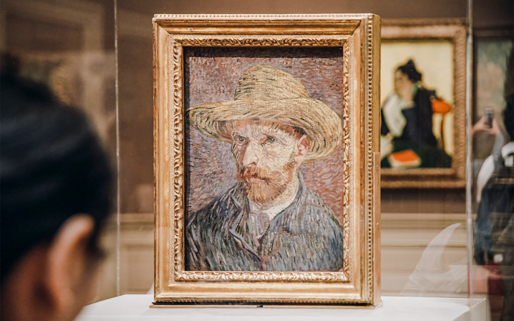 Vincent van Gogh's self-portrait with straw hat in gold frame at Metropolitan Museum of Art.