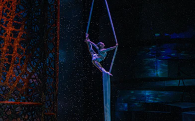Aerial performer at La Perle show in Dubai, suspended on silk ropes.