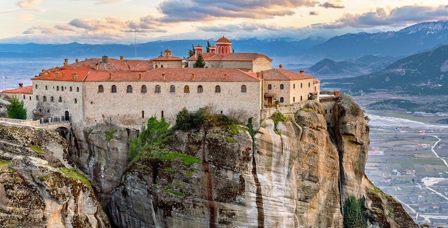Meteora monastery perched on rock formation, view from 1-day train tour from Athens.