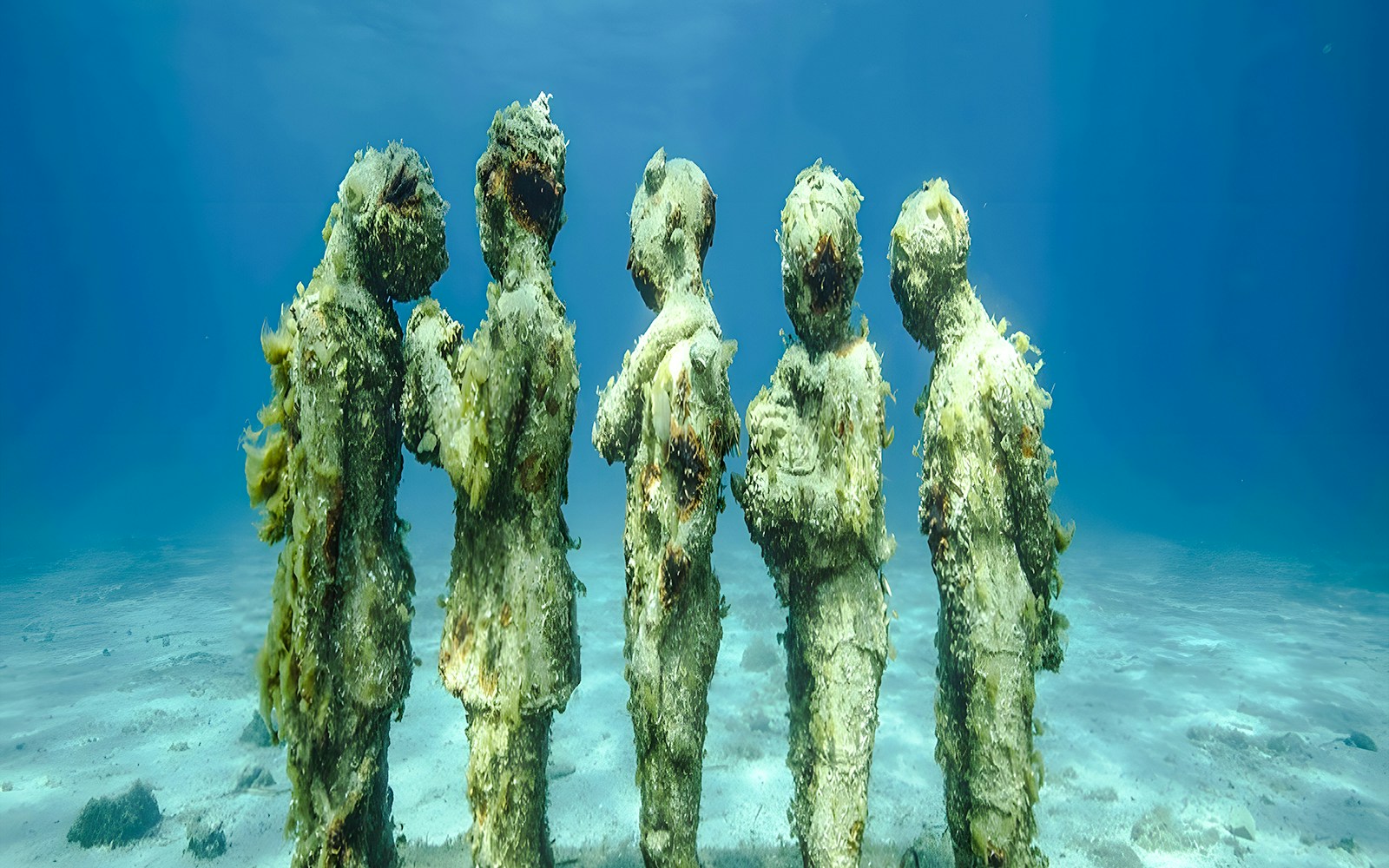 Underwater statues covered in algae at the Underwater Museum of Marseille.