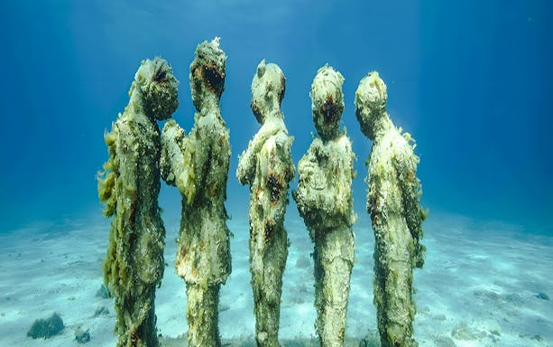 Underwater statues in Marseille's Underwater Museum, France, showcasing marine life and art.