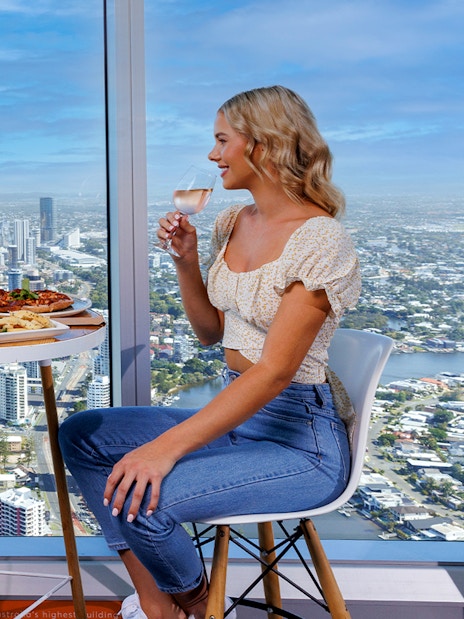 Couple dining with ocean and city views at SkyPoint Observation Deck, Gold Coast.