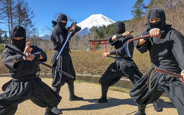 Ninjas posing with weapons in front of Mt. Fuji during Hakone day tour from Tokyo.