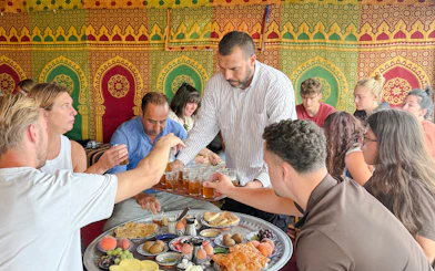 Man serving traditional Berber breakfast in caidal tent after hot air balloon ride, Marrakech.