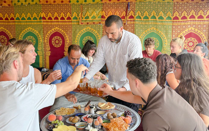 Man serving traditional Berber breakfast in caidal tent after hot air balloon ride, Marrakech.