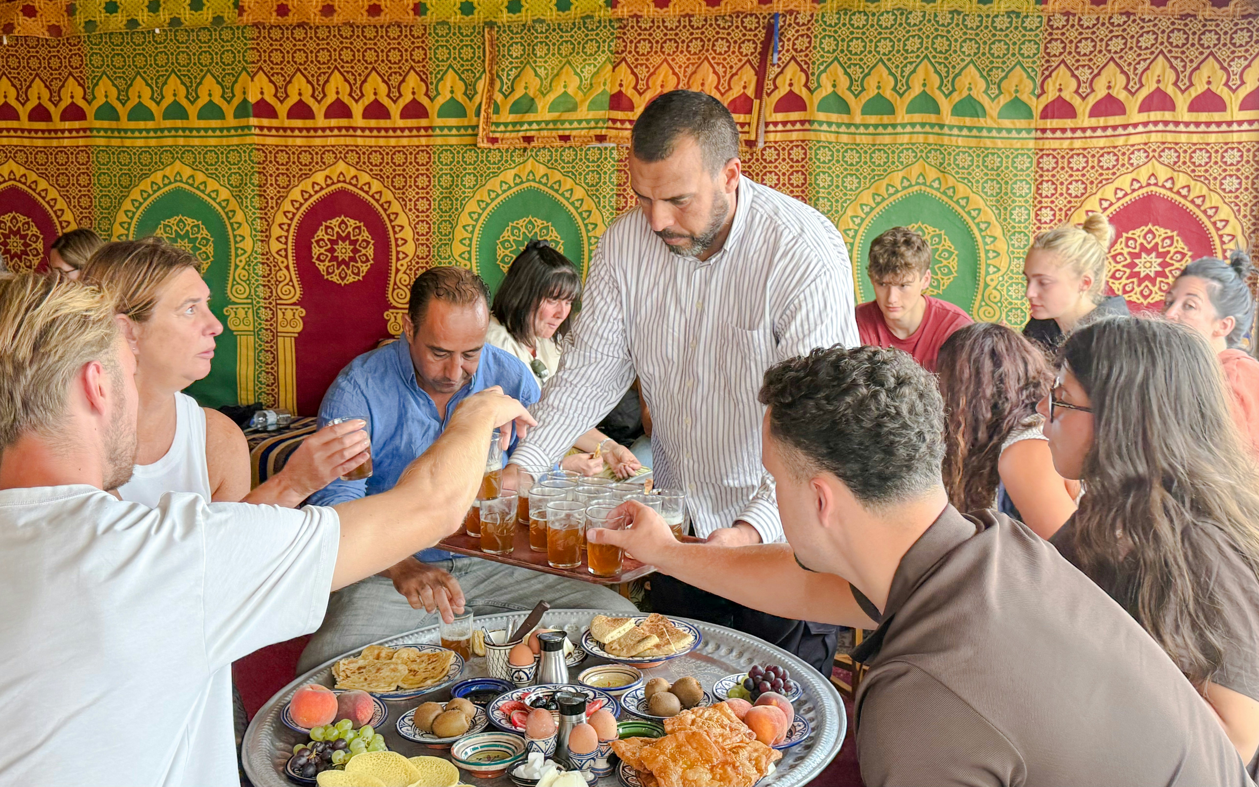 Man serving traditional Berber breakfast in caidal tent after hot air balloon ride, Marrakech.