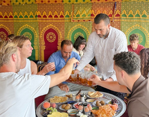Man serving traditional Berber breakfast in caidal tent after hot air balloon ride, Marrakech.