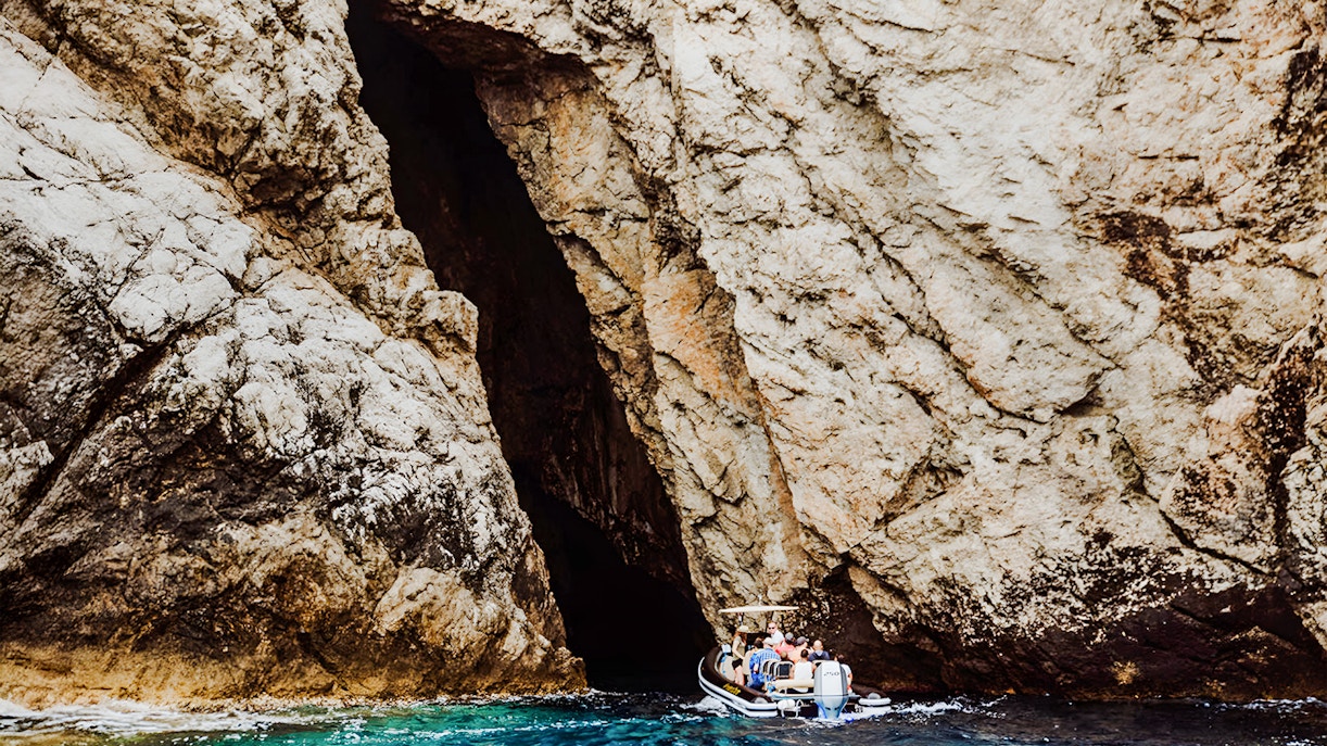 Boat entering Monk Seal Cave on Blue Cave, Blue Lagoon & 5 Islands tour.