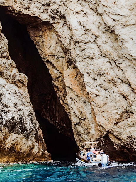Boat entering Monk Seal Cave on Blue Cave, Blue Lagoon & 5 Islands tour.