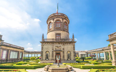 Chapultepec Castle tower in Mexico City with surrounding gardens and historic architecture.
