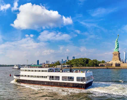 Ferry approaching Statue of Liberty with New York City skyline in background.
