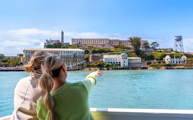 Ferry approaching Alcatraz Island from San Francisco’s Pier 33, with visitors pointing at the historic prison.
