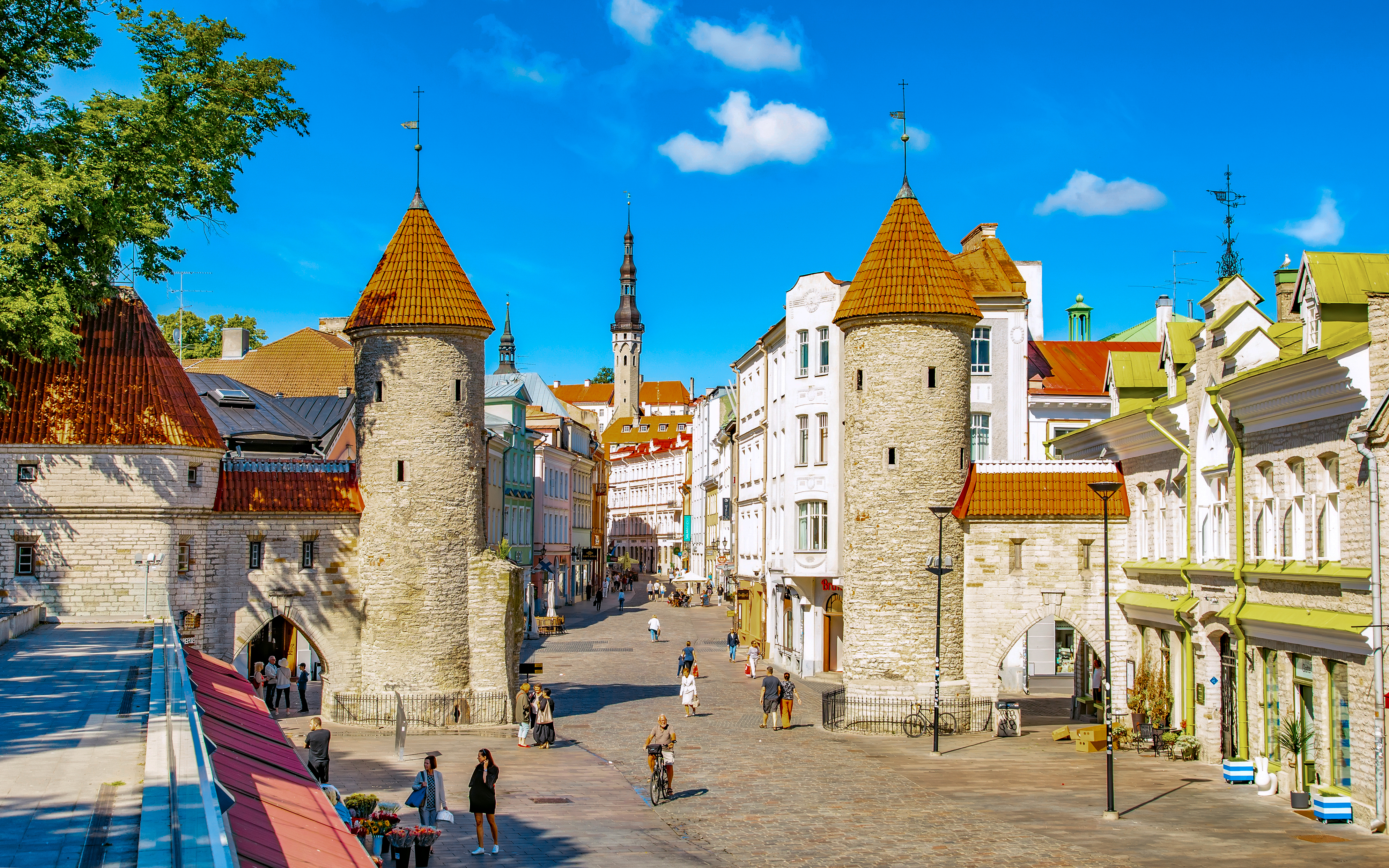 Viru Gate towers in Tallinn Old Town, Estonia, with cobblestone street and historic buildings.