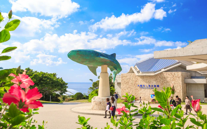 Churaumi Aquarium entrance with whale shark statue, Okinawa Hip Hop Bus Tour.