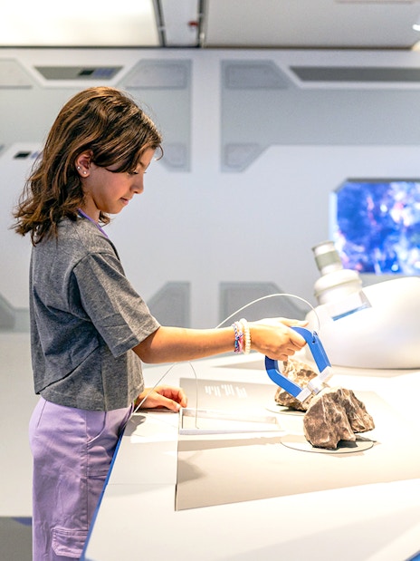 Young visitor exploring exhibit at Louvre Abu Dhabi.