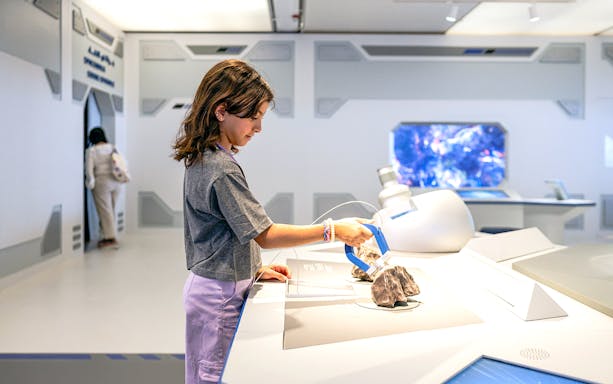 Young visitor exploring exhibit at Louvre Abu Dhabi.