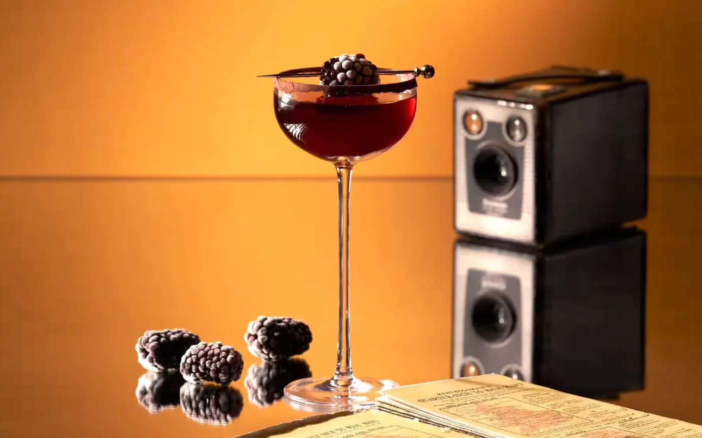 Dark red cocktail in a coupe glass with sugar rim and blackberry garnish, Resorts World Sentosa Singapore.