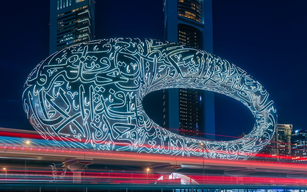 Museum of the Future illuminated at night in Dubai with Arabic calligraphy.