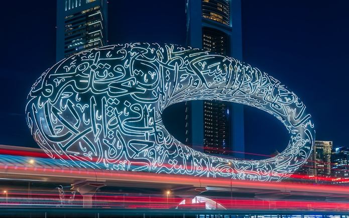 Museum of the Future illuminated at night in Dubai with Arabic calligraphy.