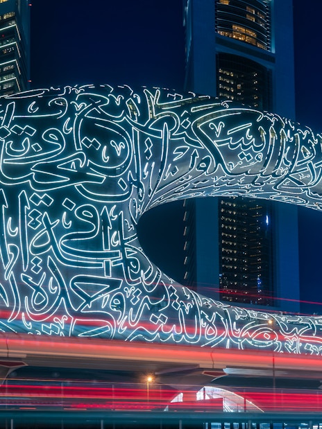Museum of the Future illuminated at night in Dubai with Arabic calligraphy.