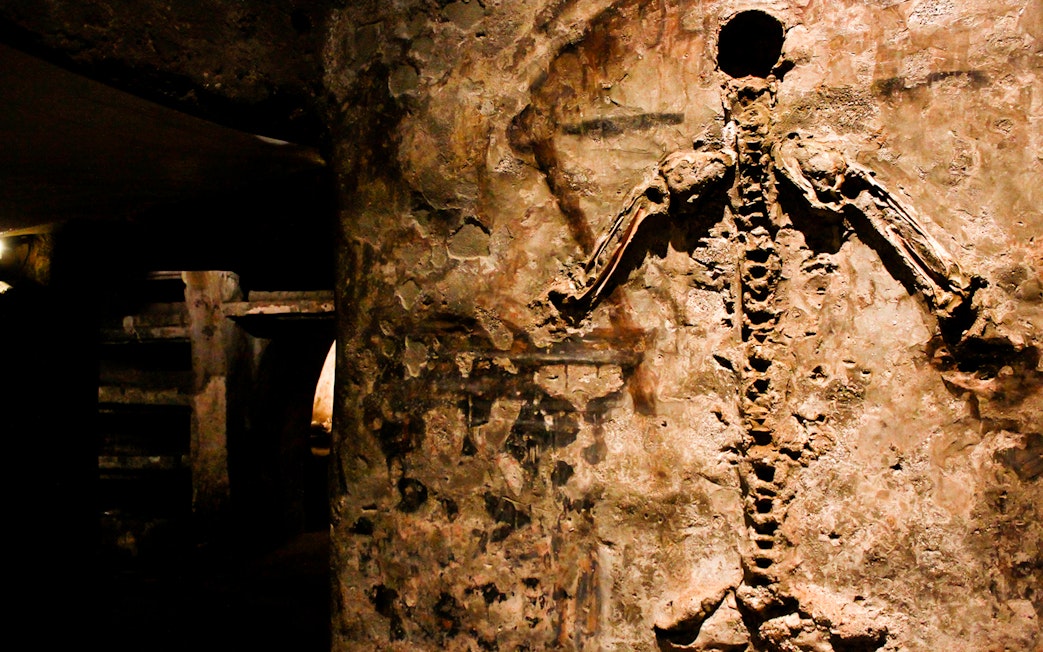 Visitors viewing skeletal remains in the Catacombs of San Gaudioso, Naples, Italy.