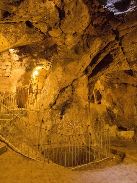 Cappadocia's Kaymakli Underground City with stone stairs and illuminated tunnels.