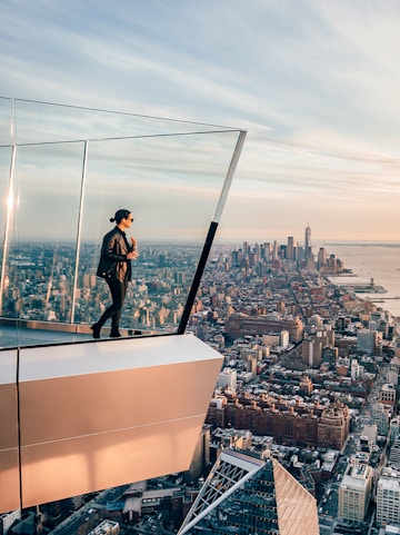 Women standing on Edge NYC observation deck overlooking Manhattan skyline.