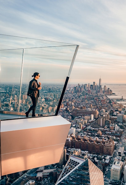 Women standing on Edge NYC observation deck overlooking Manhattan skyline.