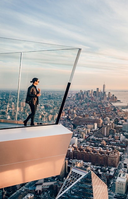 Women standing on Edge NYC observation deck overlooking Manhattan skyline.