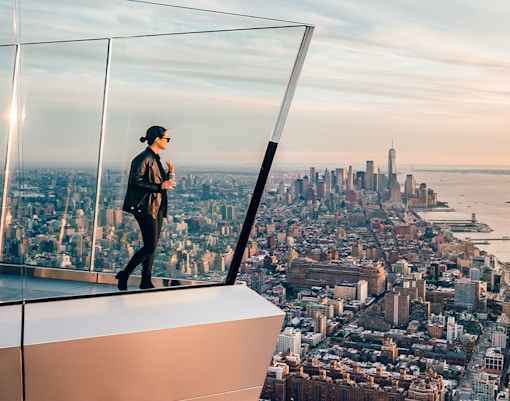 Women standing on Edge NYC observation deck overlooking Manhattan skyline.