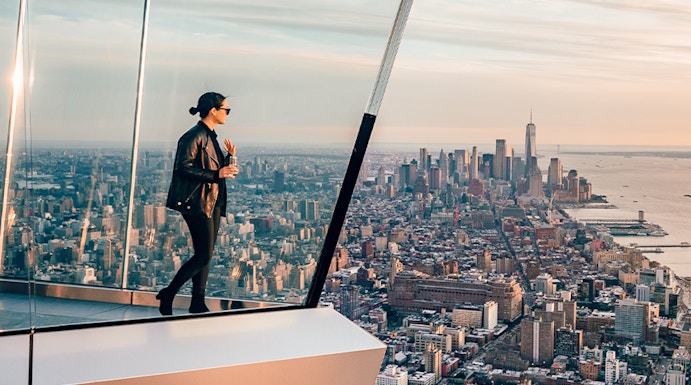 Women standing on Edge NYC observation deck overlooking Manhattan skyline.