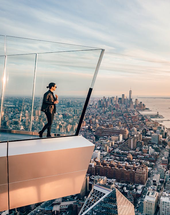 Women standing on Edge NYC observation deck overlooking Manhattan skyline.