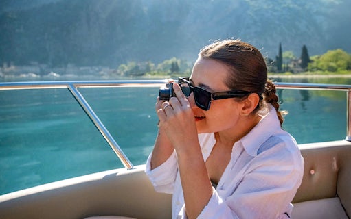 Guest taking photos on catamaran during Blue Cave cruise tour.