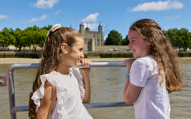 Guests enjoying the Tower of London cruise with the historic castle in the background.