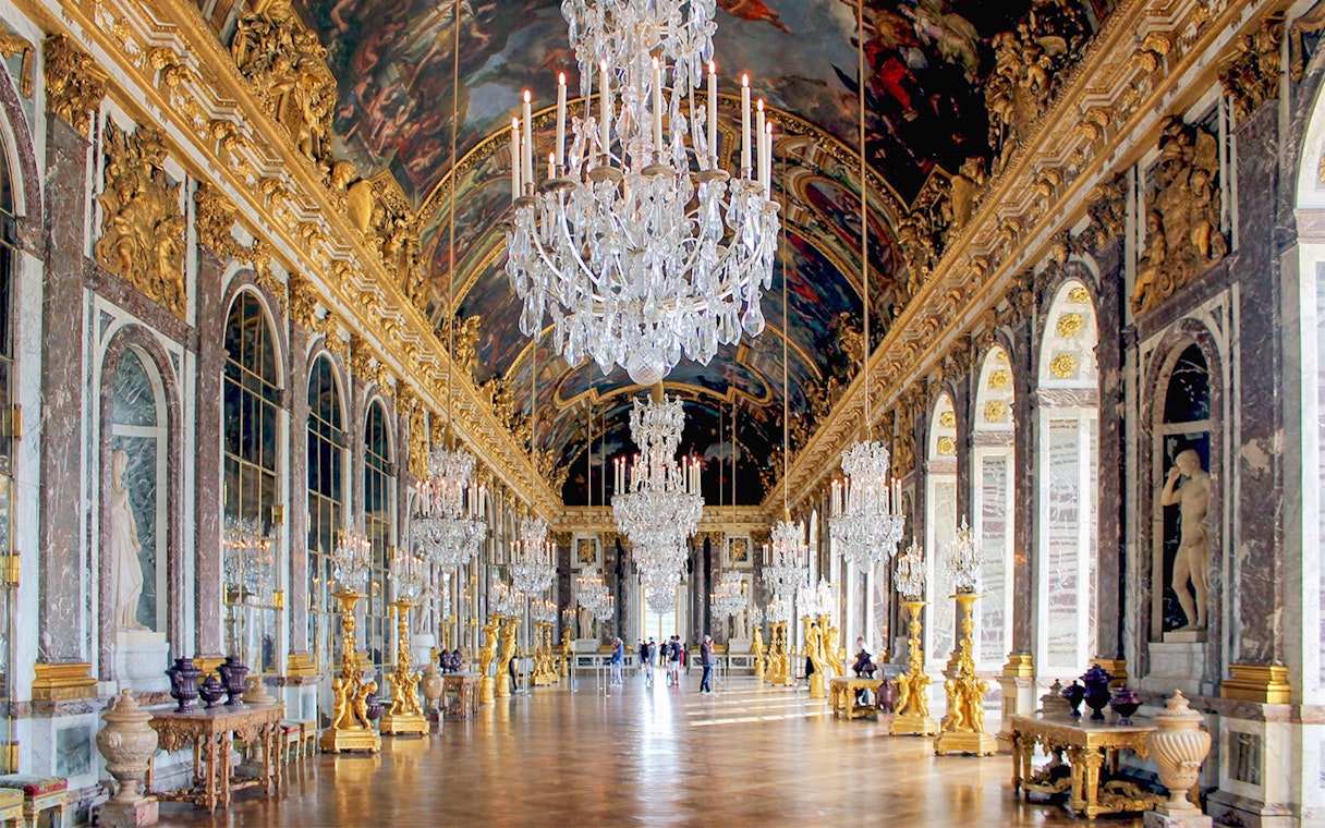 Versailles Palace Hall of Mirrors with chandeliers and ornate decor, part of guided tour from Paris.
