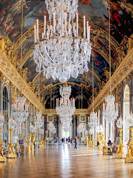 Versailles Palace Hall of Mirrors with chandeliers and ornate decor, part of guided tour from Paris.