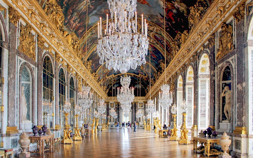 Versailles Palace Hall of Mirrors with chandeliers and ornate decor, part of guided tour from Paris.