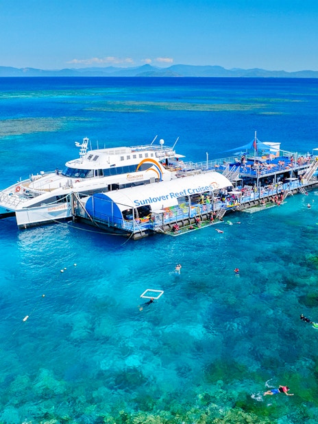 Cruise ship and pontoon near Moore Reef, Great Barrier Reef, Australia, with snorkelers in clear water.