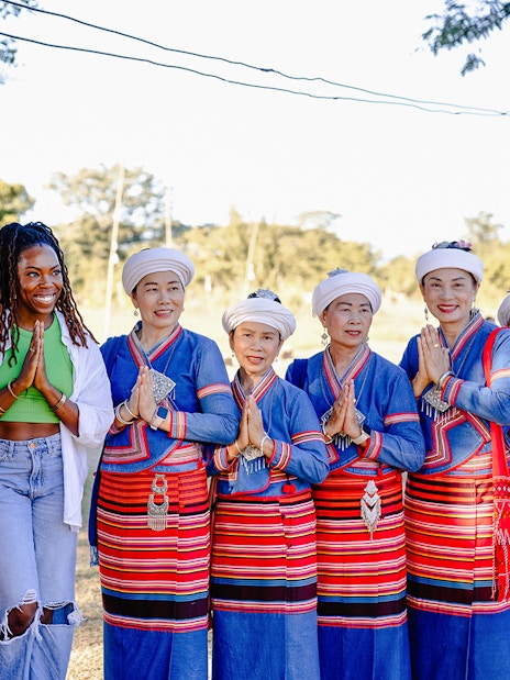 Thai women in traditional dress greet a visitor during Yi Peng and Loy Krathong Festival 2025, Chiang Mai.