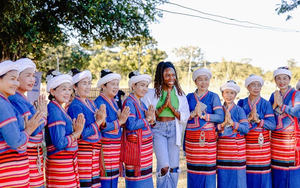Thai women in traditional dress greet a visitor during Yi Peng and Loy Krathong Festival 2025, Chiang Mai.